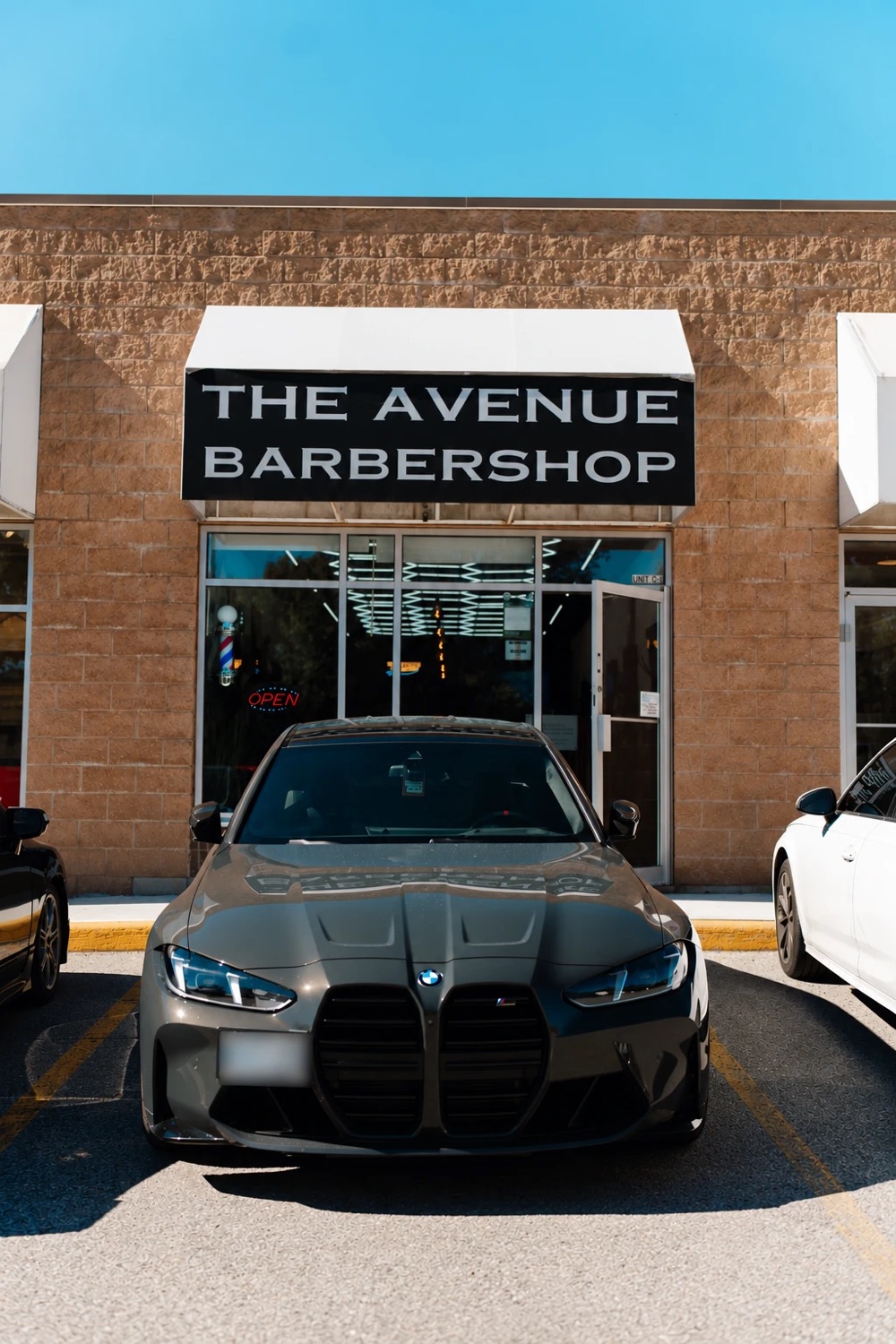 The Avenue Barbershop storefront at 11000 Yonge St, with its black sign above the entrance